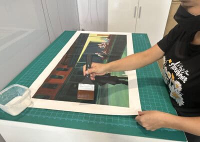 Person using a heat press machine to print on fabric at Poppins Shop.