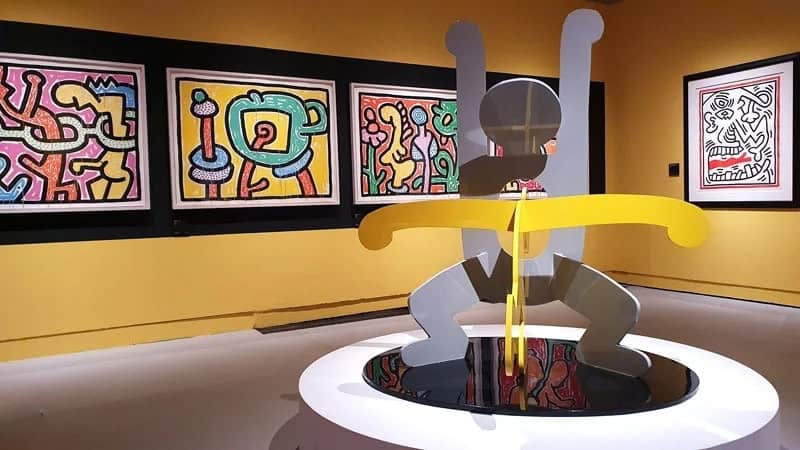 Modern Keith Haring bunny sculpture displayed in an art gallery setting.