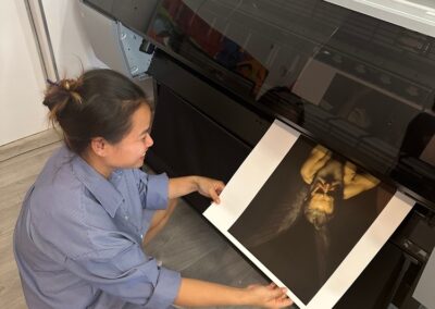 Woman operating large format printer printing high-quality photo.