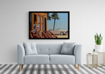 Bright living room with a large framed artwork, white sofa, and stylish side tables.