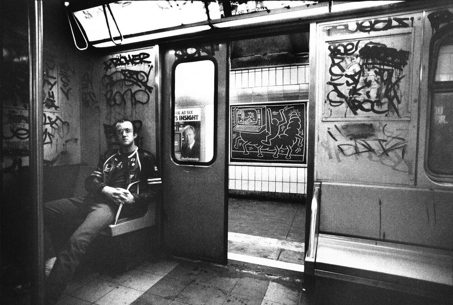 A vibrant street scene in 1980s New York, showcasing Keith Haring's iconic visual language and symbols prominently in the foreground. Bold, colorful figures and abstract shapes with fluid lines encapsulate the energetic spirit of the time. The middle ground features urban elements like graffiti-covered walls and bustling pedestrians dressed in period-appropriate attire, exuding a sense of community and creativity. In the background, the city's skyline rises under a bright blue sky, bathed in warm sunlight that enhances the vivid colors and playful energy of the scene. The composition is dynamic, emphasizing movement and urban culture. Illuminate the scene with a soft, golden hour glow for a nostalgic mood, making it feel lively yet harmonious, with a touch of artistic flair, reflecting the vibrancy associated with Keith Haring and his work for the Poppins Shop.